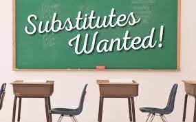Desks with green chalkboard and text Substitutes wanted!