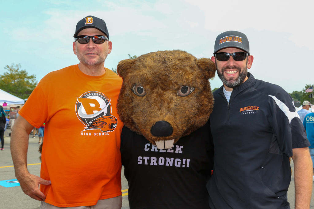 Two men pose with Bucky the Beaver mascot 