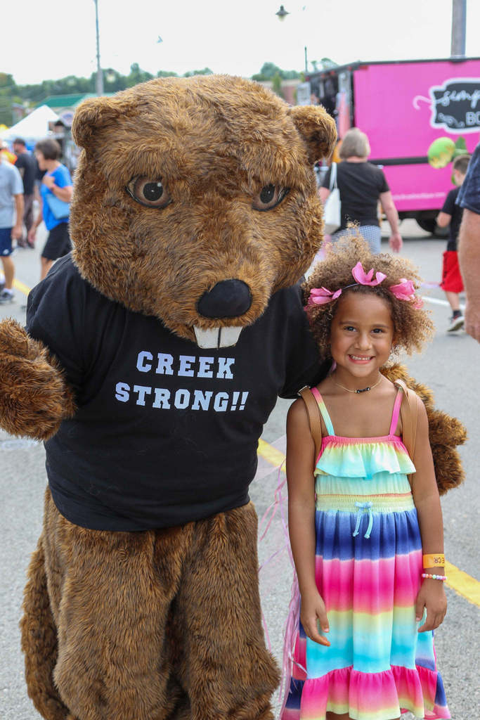 Young girl poses with Bucky the Beaver mascot 