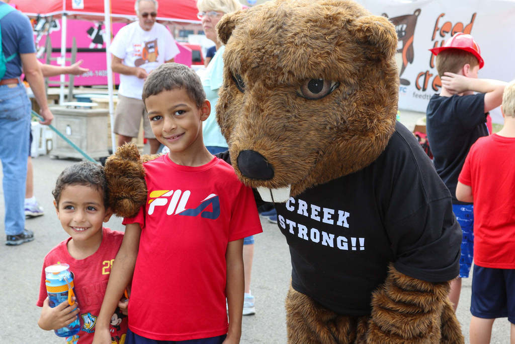 Two boys pose with Bucky the Beaver mascot 