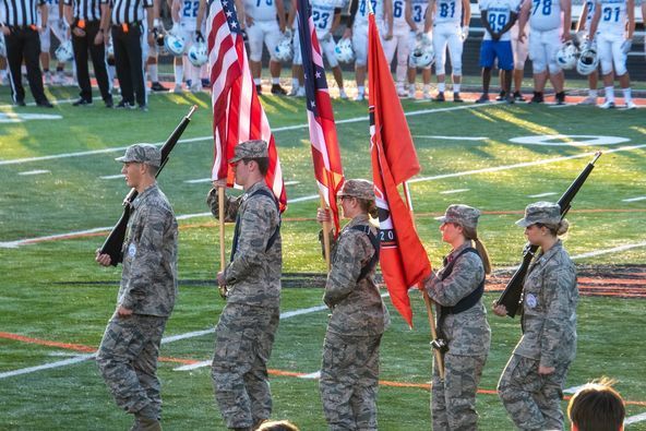 JROTC students carry flags onto field