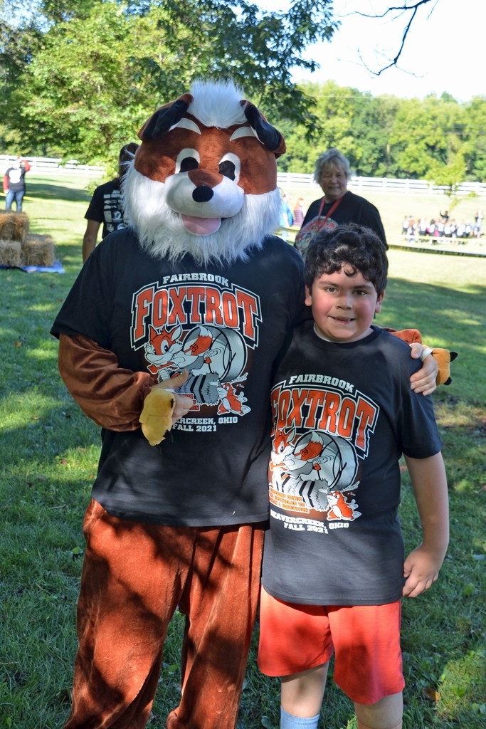Boy poses with school fox mascot
