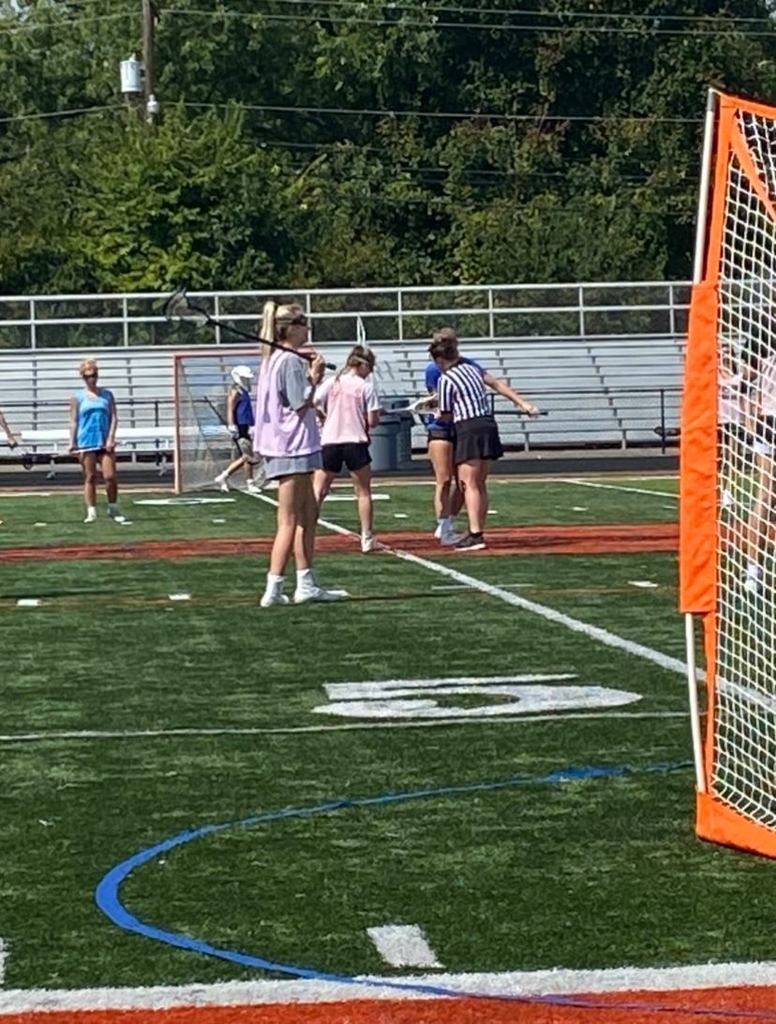 Female lacrosse players prepare for start of play