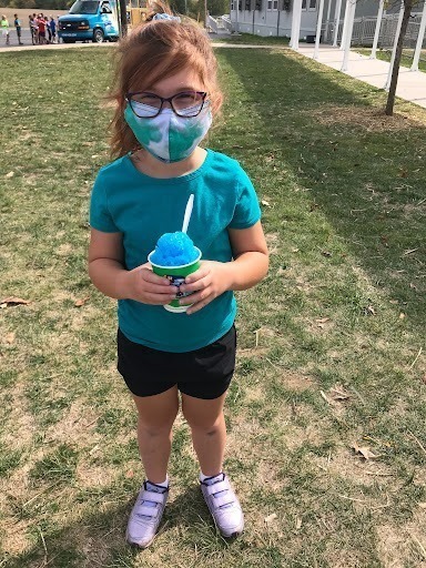 Child poses with her blue snow cone