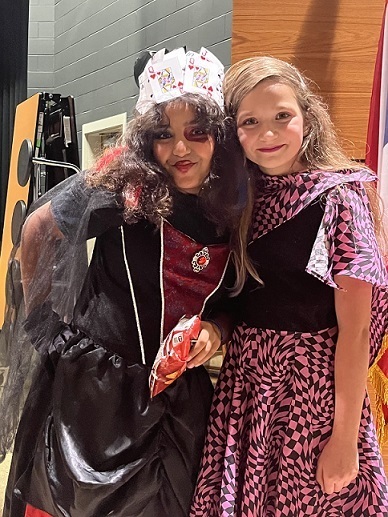Two friend dressed as the queen of hearts and 50's