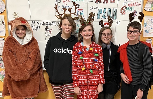 Reindeer Games Day- 4 students with antlers and 1 student in a reindeer costume posing together smiling