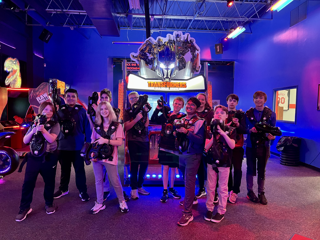 12 students in friends club with lazer tag equipment on posing in a group at the lazer tag facility